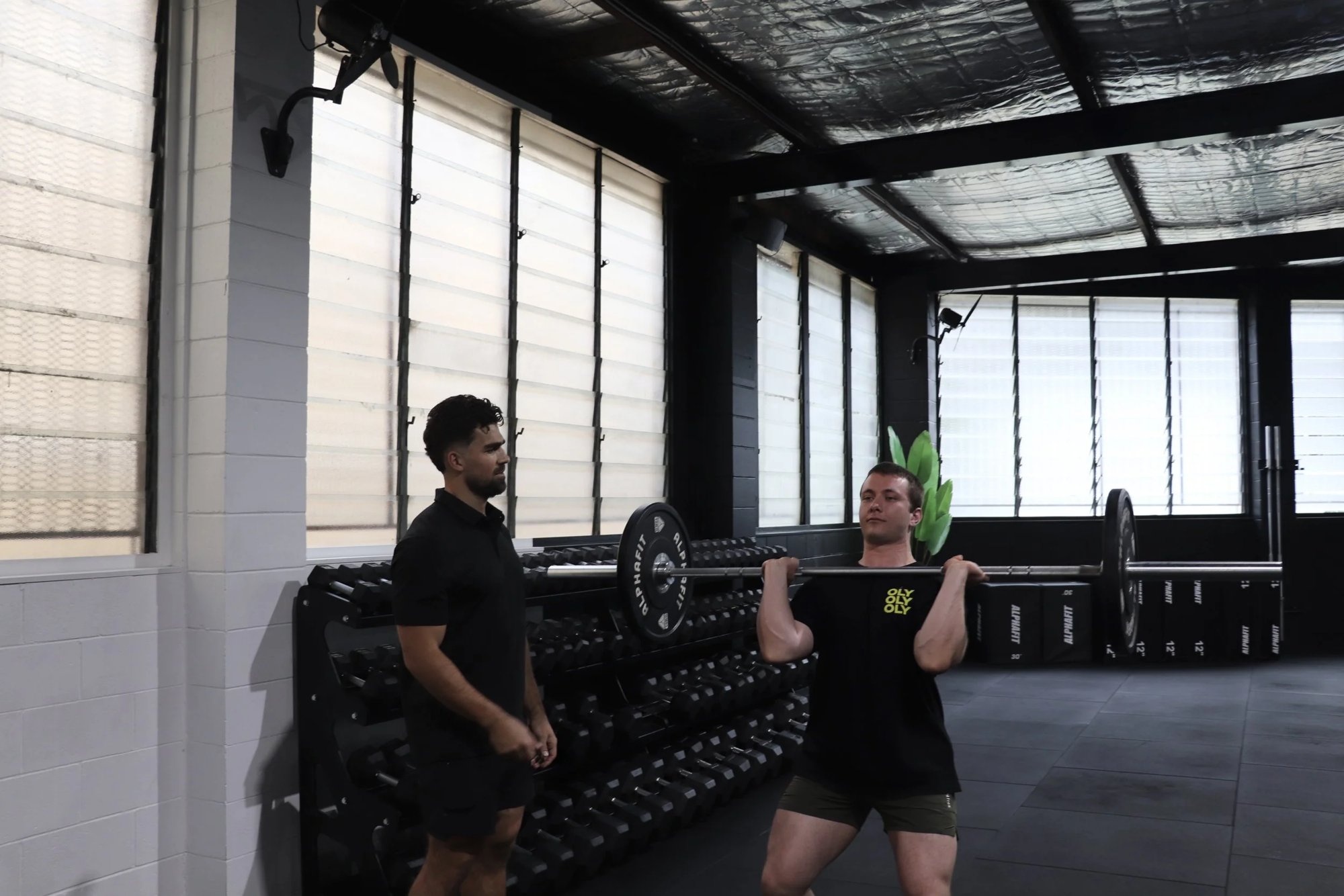 Coaching the front rack inside Never Quit gym